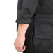 A man wearing a black Chef Revival long sleeve chef jacket with a mesh back.