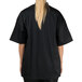 A woman wearing a black Chef Revival chef jacket with mesh back.