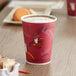 A red Solo Bistro print paper hot cup filled with coffee on a table.