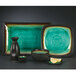 A Libbey stoneware plate with round detailing on a table with a black vase and a lemon.