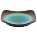A blue stoneware plate with round detailing.