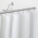 A white Bobrick vinyl shower curtain hanging in a shower.