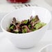 An American Metalcraft white melamine bowl filled with salad on a table.