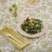 A Bambu Veneerware bamboo plate with a salad and a fork on a table.