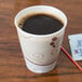 A Solo foam cup filled with brown liquid on a table.