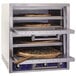 Three pizzas cooking inside a Bakers Pride countertop oven.
