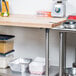 An Advance Tabco wood top work table with a stainless steel base and undershelf.