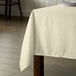 An ivory rectangular table cover on a wooden table.