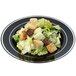 A salad with croutons on a black Fineline Silver Splendor plastic plate with silver bands.