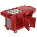 A red plastic container with a large open door on a Cambro Versa Ultra work table.