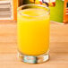 A Libbey Lexington juice glass filled with orange juice on a table.