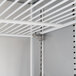 A white metal shelf with white rods inside a Beverage-Air back bar refrigerator.