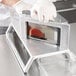 A person using a Vollrath InstaSlice machine to cut fruit.