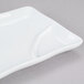 a white square plate with a handle