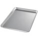 A Chicago Metallic aluminum bun pan with a semi-curled rim on a counter.