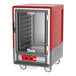 A red and grey Metro C5 heated holding cabinet with wheels.