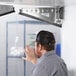 A man using a Curtron Polar-Pro swinging door in a food truck.