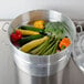 A Town aluminum steamer water pan filled with vegetables on a stove.