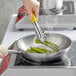 a person cooking asparagus in a pan