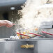 A person using a Crown Verity outdoor fryer to cook food on a counter.