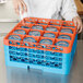 A woman using a Carlisle orange glass rack with glasses inside.