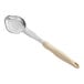 A close-up of a Vollrath ivory and beige solid oval Spoodle portion spoon.