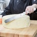 A person using a Tablecraft baking / icing spatula to cut a cake.