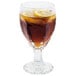 A Libbey Chivalry goblet filled with brown liquid and lemon slices.