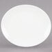 A Tuxton Venice oval coupe china platter in eggshell white on a white background.