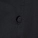 A close up of the back of a black Chef Revival chef coat with buttons.