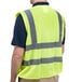 A man wearing a Cordova lime high visibility safety vest over a black shirt.