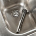 An Eagle Group stainless steel underbar sink with two drainboards and a metal pipe.