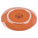 A close-up of a Libbey terracotta fern green plate with a white logo on it.