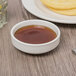 A Libbey ivory porcelain bowl filled with brown sugar on a table with pancakes.