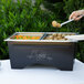 A person serving food from a Sterno ChalkBoard Chafer on a buffet table.