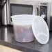 A translucent plastic container with a white lid on a counter top.