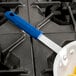 A blue Vollrath Cool Handle II on a pan.