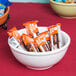 A white Cal-Mil melamine bowl filled with candy on a table.