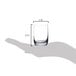 A hand holding a Stolzle Weinland shot glass with measurements.