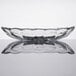 An Anchor Hocking clear glass banana split dish on a reflective surface.