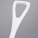 A white plastic Carlisle Sparta ice shovel with a white handle.