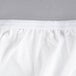 A close up of a L.A. Baby white cotton fitted crib sheet.