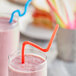 A glass of smoothie with a Choice jumbo neon crazy straw in it.