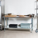 A stainless steel Advance Tabco work table with a galvanized undershelf.