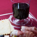 A WNA Comet clear plastic cocktail plate with wine and snacks on it.