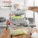 A person using a Nemco Easy LettuceKutter to cut lettuce.