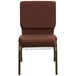 A brown Flash Furniture church chair with metal legs and a book rack.