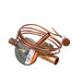 A close-up of a copper pipe with a wire attached to it.
