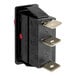 A black rectangular electrical switch with two red buttons.