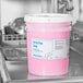 A white bucket of Advantage Chemicals concentrated pot and pan soap on a counter.